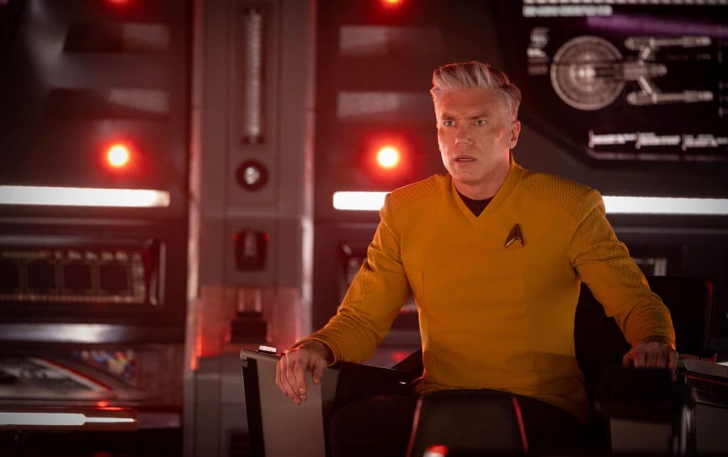 Foto von Captain Pike auf der Brücke der USS-Enterprise. Im Hintergrund Lampen des roten Alarms